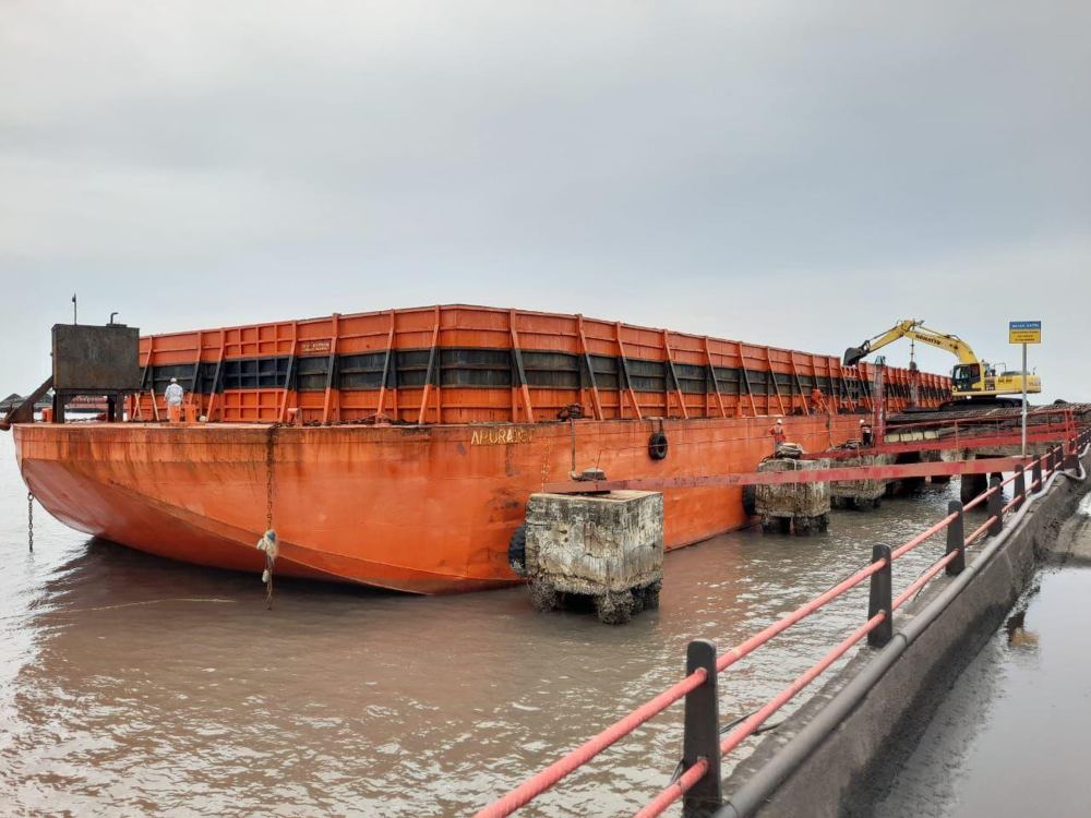Tongkang bermuatan sedang bongkar muat batu bara di jetty